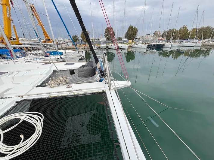 Avra Yacht Photos Pics Lagoon 560 S2 catamaran docked in a marina, 2014 model, calm waters, overcast sky.
