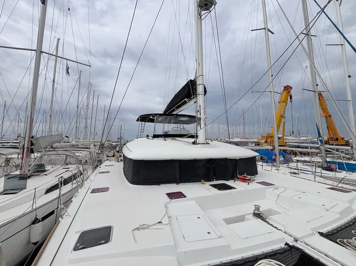 Avra Yacht Photos Pics 2014 Lagoon 560 S2 catamaran docked in a marina, surrounded by other boats.
