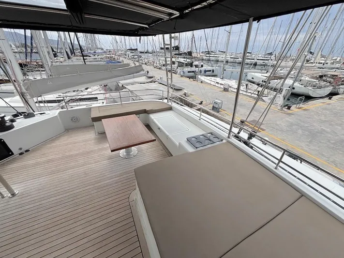 Avra Yacht Photos Pics Spacious deck of 2014 Lagoon 560 S2 yacht in marina, featuring seating and table.