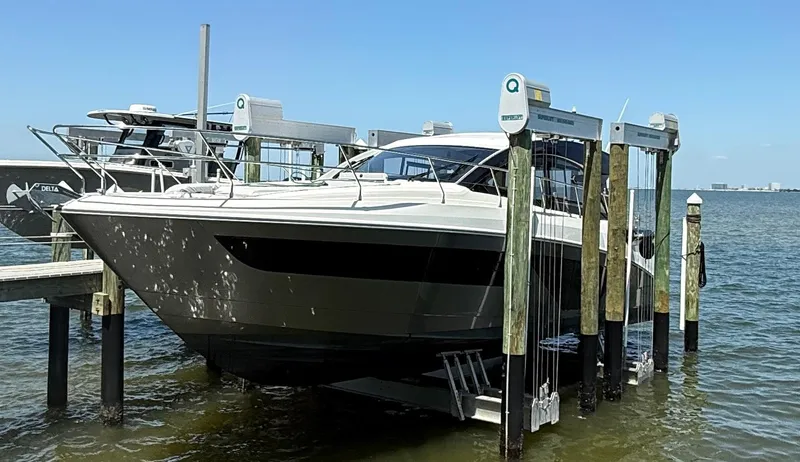  Yacht Photos Pics 2023 Beneteau Gran Turismo 45 yacht docked on a lift in a marina.