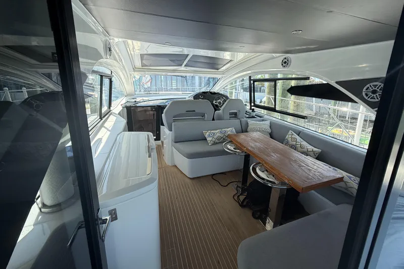  Yacht Photos Pics 2023 Beneteau Gran Turismo 45 interior with modern seating and wooden table.