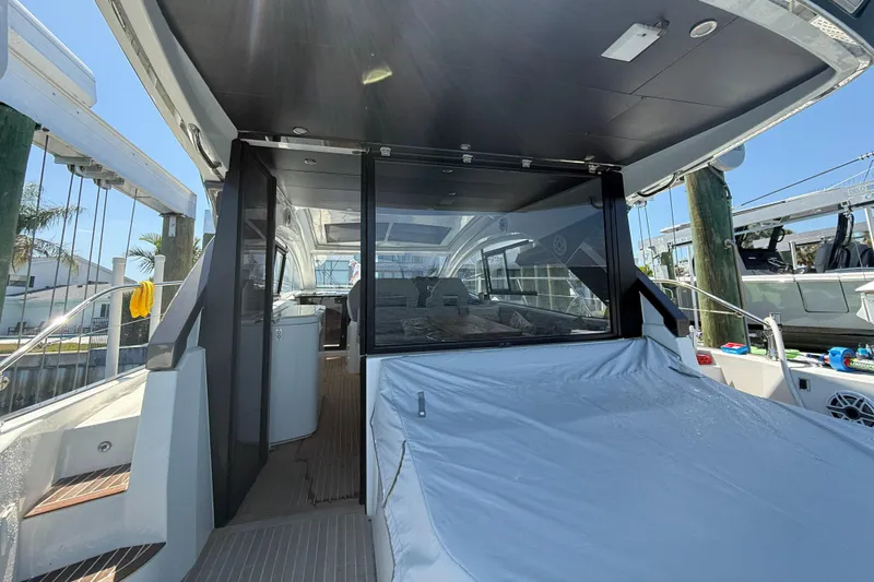  Yacht Photos Pics 2023 Beneteau Gran Turismo 45 yacht interior with covered seating area and modern design.