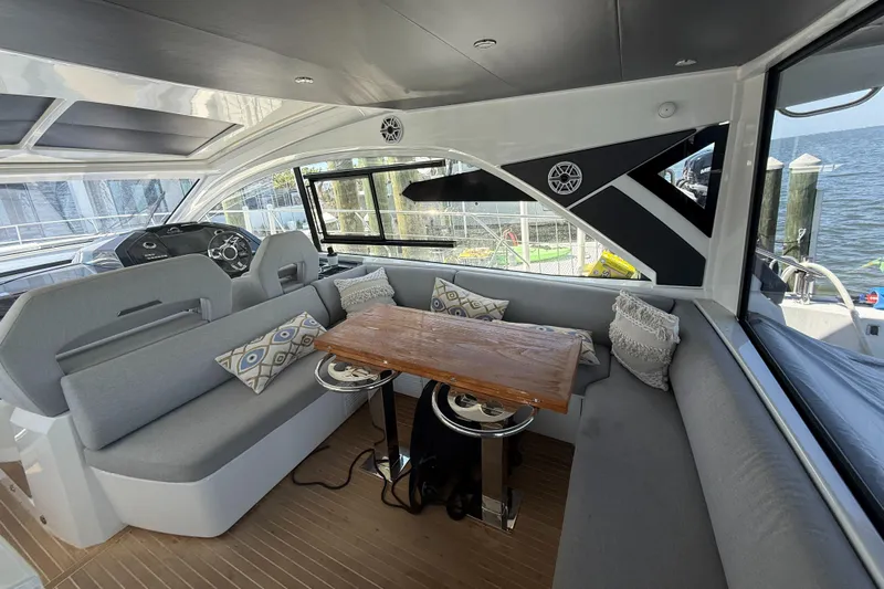 Yacht Photos Pics Luxurious interior of 2023 Beneteau Gran Turismo 45 yacht with elegant seating and wooden table.