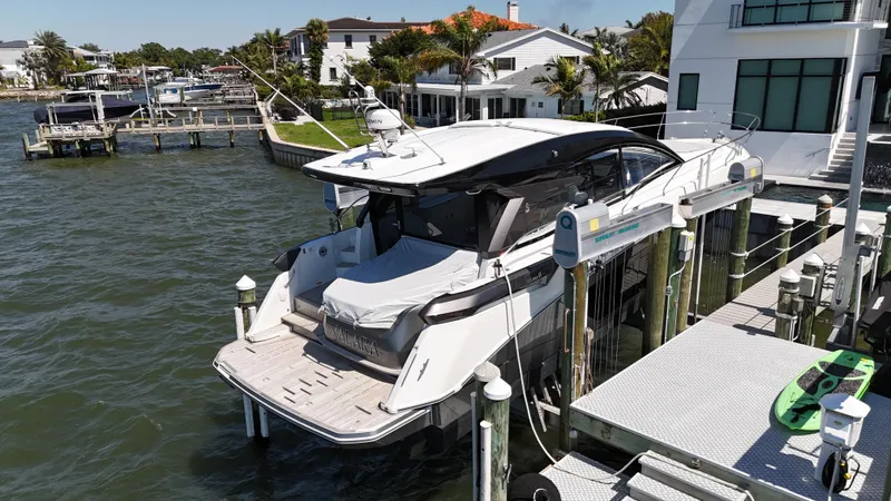  Yacht Photos Pics 2023 Beneteau Gran Turismo 45 yacht docked by waterfront homes.