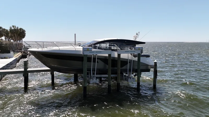  Yacht Photos Pics 2023 Beneteau Gran Turismo 45 yacht docked on a lift over water.