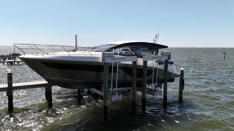  Yacht Photos Pics 2023 Beneteau Gran Turismo 45 yacht docked on a lift over water.