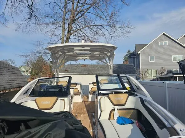  Yacht Photos Pics 2023 Yamaha Boats 275 SDX in residential driveway, showcasing sleek design and spacious interior.
