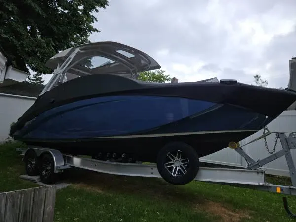 Yacht Photos Pics 2023 Yamaha Boats 275 SDX on trailer, sleek design, dark blue hull.