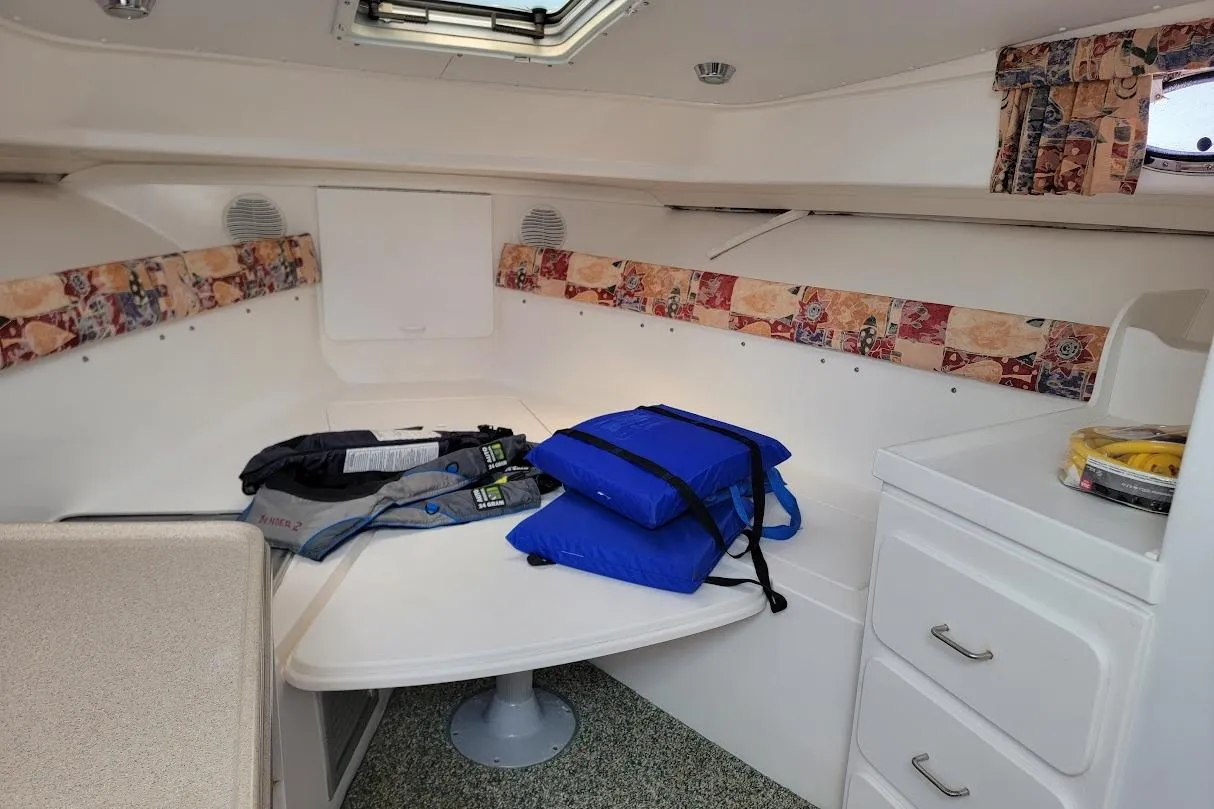 Interior cabin of 2000 Stamas 310 Express boat with life jackets on table.