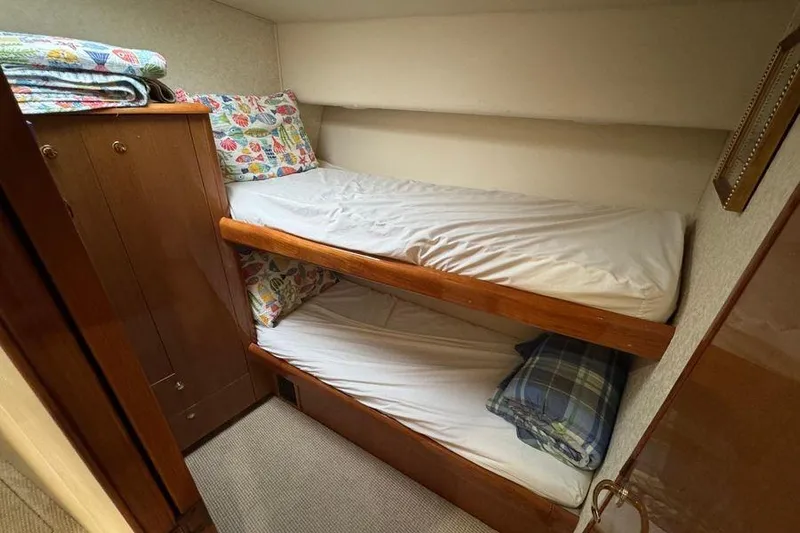 Miss Maggie Yacht Photos Pics Bunk beds in 2002 Viking 61 Enclosed Bridge yacht cabin with colorful bedding.