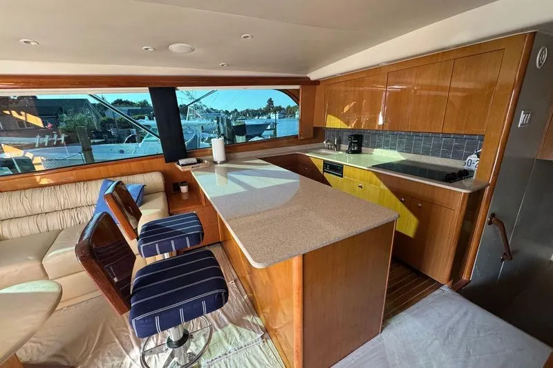 Miss Maggie Yacht Photos Pics Luxurious interior of 2002 Viking 61 Enclosed Bridge yacht with modern kitchen and seating area.