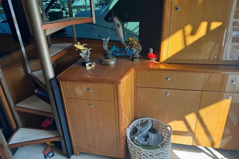 Miss Maggie Yacht Photos Pics Interior of 2002 Viking 61 Enclosed Bridge with wooden cabinets and decorative fish sculptures.