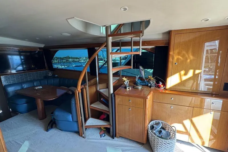 Miss Maggie Yacht Photos Pics Interior of 2002 Viking 61 Enclosed Bridge yacht with spiral staircase and seating area.