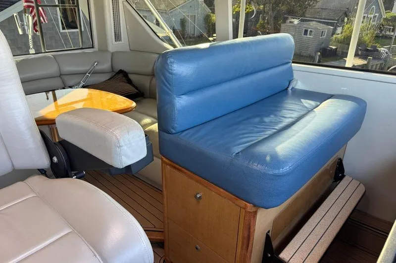 Miss Maggie Yacht Photos Pics Interior of 2002 Viking 61 Enclosed Bridge yacht with blue seating and wooden accents.