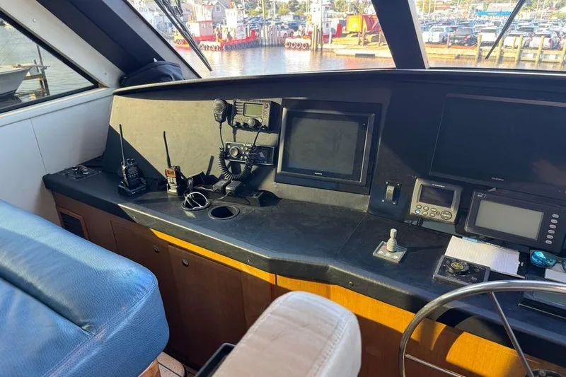 Miss Maggie Yacht Photos Pics 2002 Viking 61 Enclosed Bridge helm with navigation equipment and marina view.