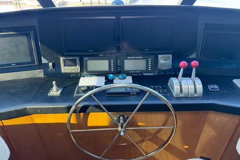 Miss Maggie Yacht Photos Pics Control panel of a 2002 Viking 61 Enclosed Bridge yacht with steering wheel and navigation equipment.