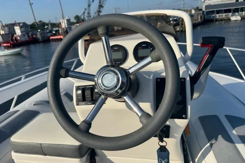 Miss Maggie Yacht Photos Pics Steering wheel of a 2002 Viking 61 Enclosed Bridge yacht, docked at a marina.
