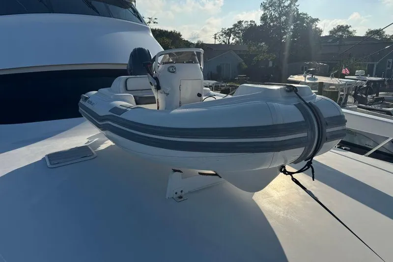 Miss Maggie Yacht Photos Pics 2002 Viking 61 Enclosed Bridge yacht with a small inflatable boat on deck.