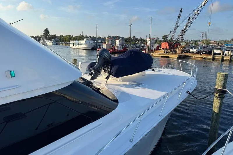 Miss Maggie Yacht Photos Pics 2002 Viking 61 Enclosed Bridge yacht docked at a marina, featuring sleek design.