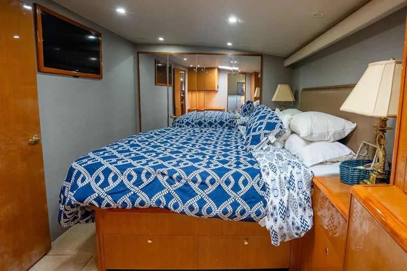Miss Maggie Yacht Photos Pics Luxurious bedroom interior of 2002 Viking 61 Enclosed Bridge yacht with blue patterned bedding.
