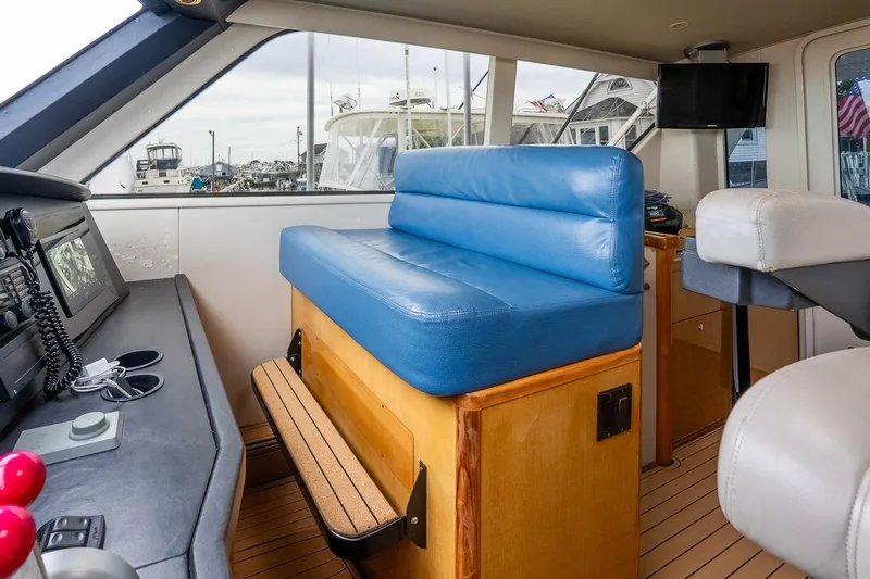 Miss Maggie Yacht Photos Pics Interior of 2002 Viking 61 Enclosed Bridge yacht with blue seating and navigation equipment.