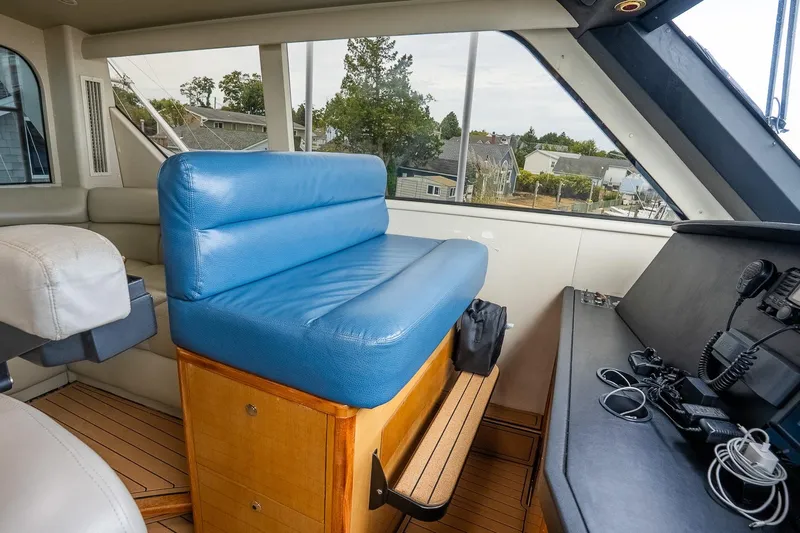 Miss Maggie Yacht Photos Pics Interior of 2002 Viking 61 Enclosed Bridge yacht with blue seating and navigation equipment.