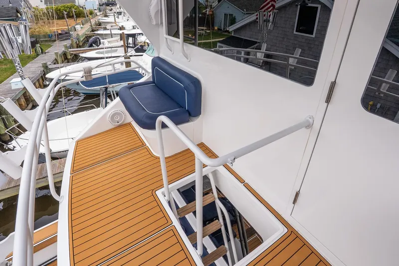 Miss Maggie Yacht Photos Pics 2002 Viking 61 Enclosed Bridge yacht with teak deck and blue cushioned seating.