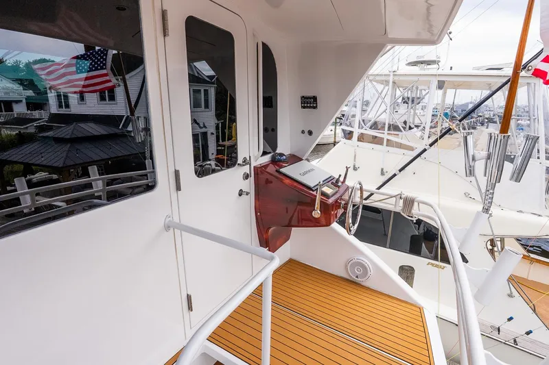 Miss Maggie Yacht Photos Pics 2002 Viking 61 Enclosed Bridge yacht helm with wooden deck and marina view.