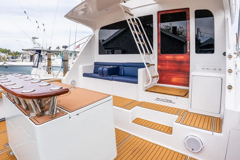 Miss Maggie Yacht Photos Pics 2002 Viking 61 Enclosed Bridge yacht with teak deck, blue seating, and fishing rod holders.