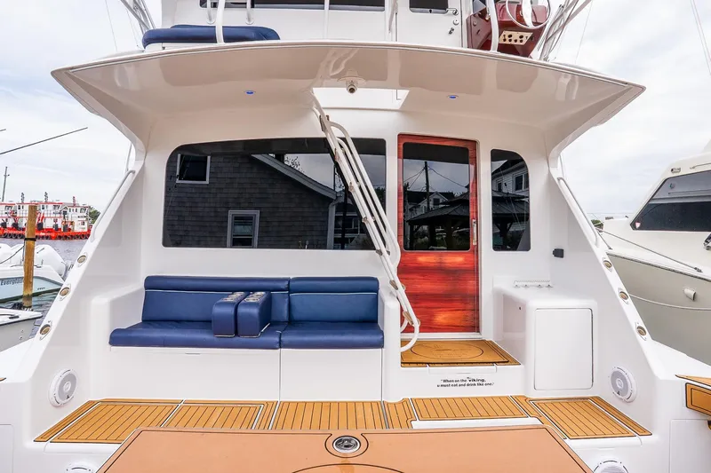 Miss Maggie Yacht Photos Pics 2002 Viking 61 Enclosed Bridge yacht with blue seating and wooden accents.