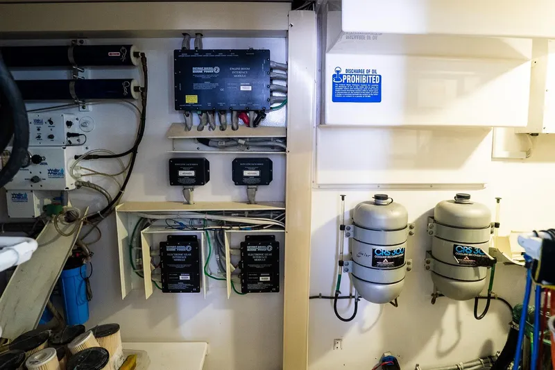 Miss Maggie Yacht Photos Pics Engine room of 2002 Viking 61 Enclosed Bridge with equipment and oil discharge warning.