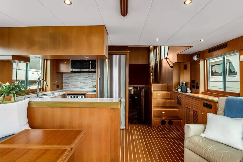 Tumbleweed Yacht Photos Pics Luxurious interior of 2016 North Pacific 49 Pilothouse yacht with modern kitchen and wooden finishes.
