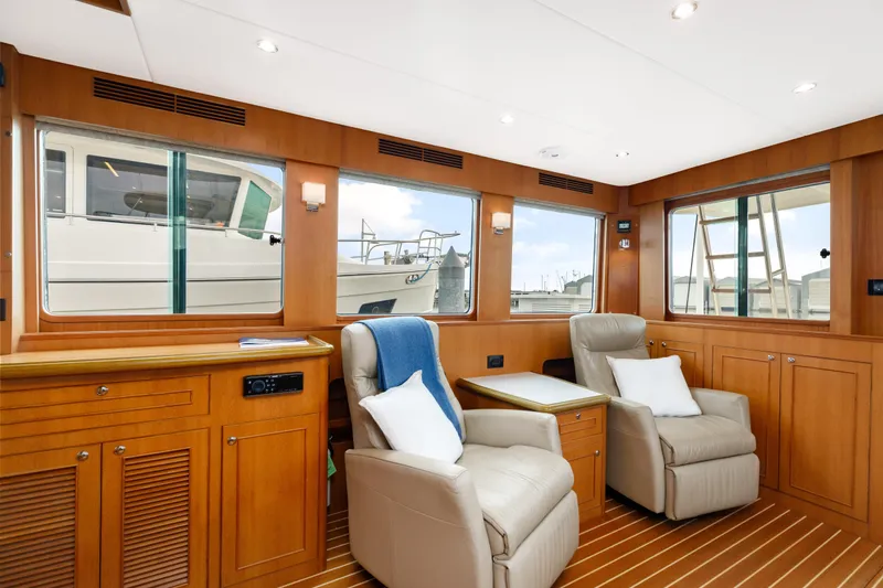 Tumbleweed Yacht Photos Pics Luxurious interior of 2016 North Pacific 49 Pilothouse with comfortable seating and wooden cabinetry.