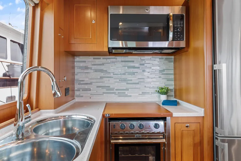 Tumbleweed Yacht Photos Pics Modern kitchen in 2016 North Pacific 49 Pilothouse yacht with stainless appliances and wood cabinetry.