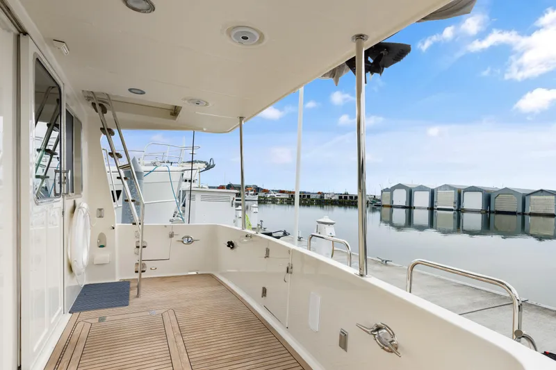 Tumbleweed Yacht Photos Pics 2016 North Pacific 49 Pilothouse yacht deck with marina view, clear sky, and calm water.