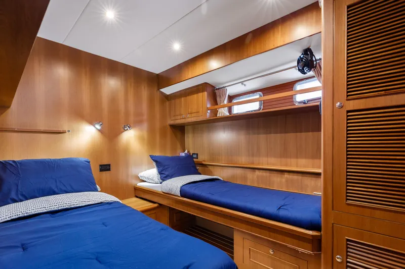 Tumbleweed Yacht Photos Pics Cozy cabin interior of 2016 North Pacific 49 Pilothouse with twin beds and wooden finish.