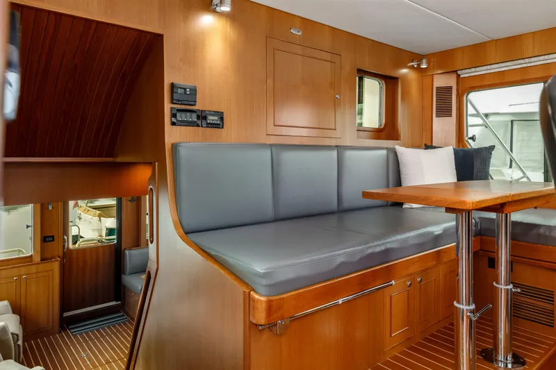 Tumbleweed Yacht Photos Pics Interior of 2016 North Pacific 49 Pilothouse with wood finish and cushioned seating.
