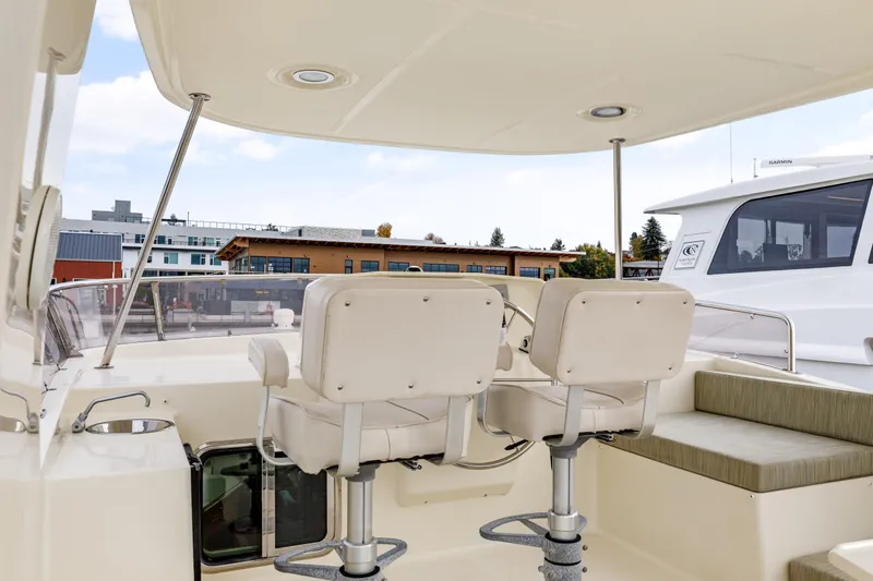 Tumbleweed Yacht Photos Pics 2016 North Pacific 49 Pilothouse yacht interior with helm chairs and seating area.