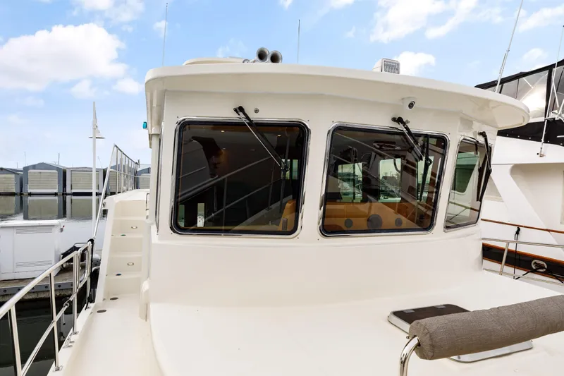 Tumbleweed Yacht Photos Pics 2016 North Pacific 49 Pilothouse yacht with large windows, docked at a marina.
