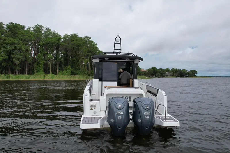  Yacht Photos Pics 2023 Jeanneau NC Sport 895 boat with dual 250 V6 engines on a calm lake.