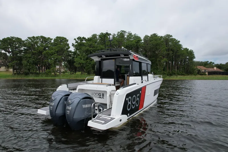  Yacht Photos Pics 2023 Jeanneau NC Sport 895 boat with twin Yamaha engines on a calm lake.