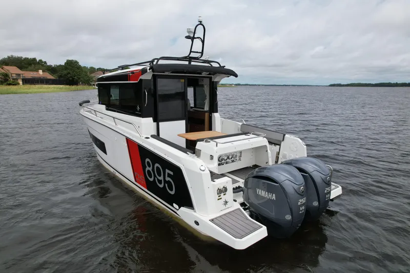  Yacht Photos Pics 2023 Jeanneau NC Sport 895 boat with twin Yamaha engines on a calm lake.
