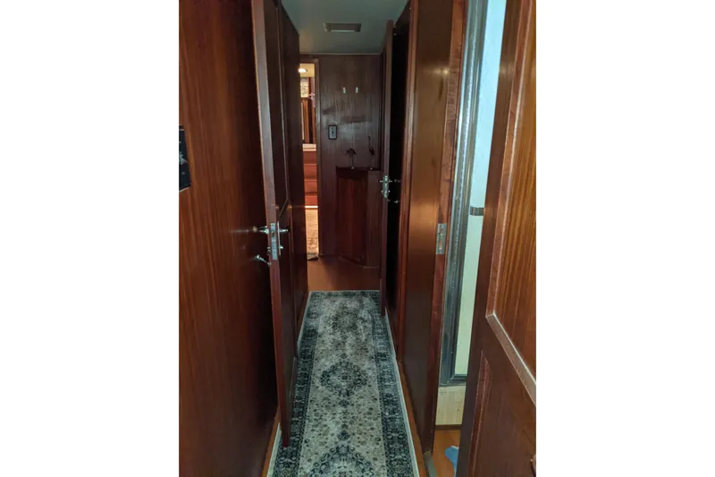 Sky To Sea Yacht Photos Pics Hallway inside 1984 Hatteras 53 Extended Deckhouse Motor Yacht with wooden doors and carpet.