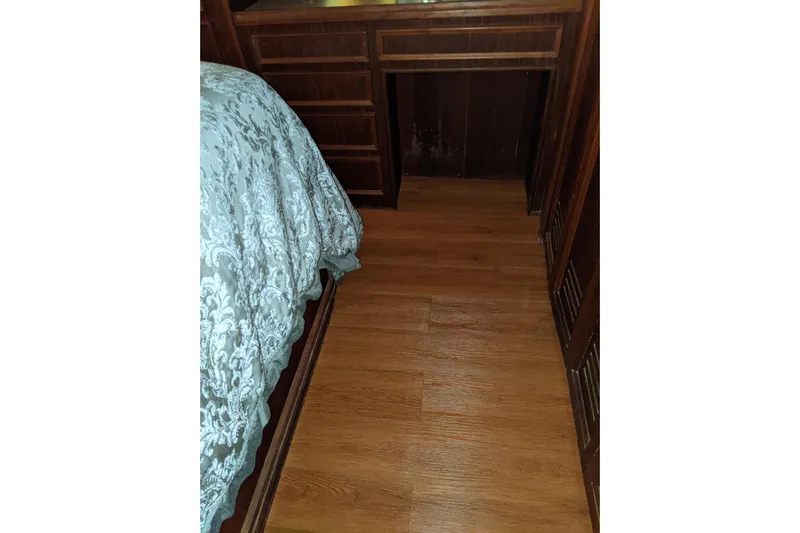 Sky To Sea Yacht Photos Pics Interior of 1984 Hatteras 53 Motor Yacht with wood flooring and elegant bedding.