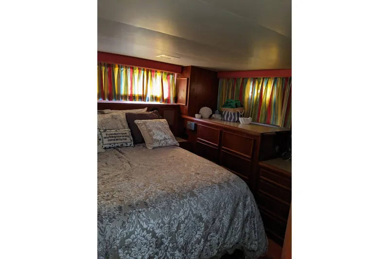 Sky To Sea Yacht Photos Pics Cozy bedroom in 1984 Hatteras 53 Motor Yacht with colorful curtains and elegant bedding.