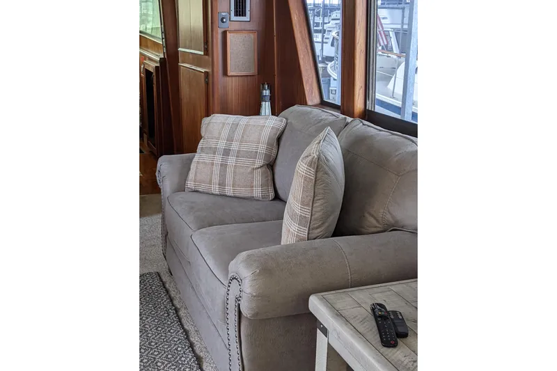 Sky To Sea Yacht Photos Pics Interior of 1984 Hatteras 53 Yacht with cozy sofa and plaid cushions.