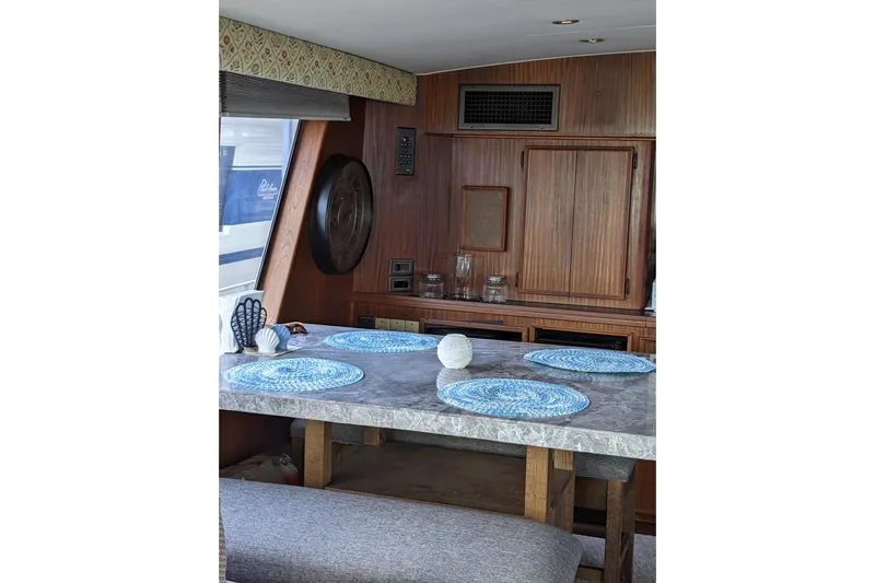 Sky To Sea Yacht Photos Pics Interior of 1984 Hatteras 53 Motor Yacht with dining area and wooden cabinetry.