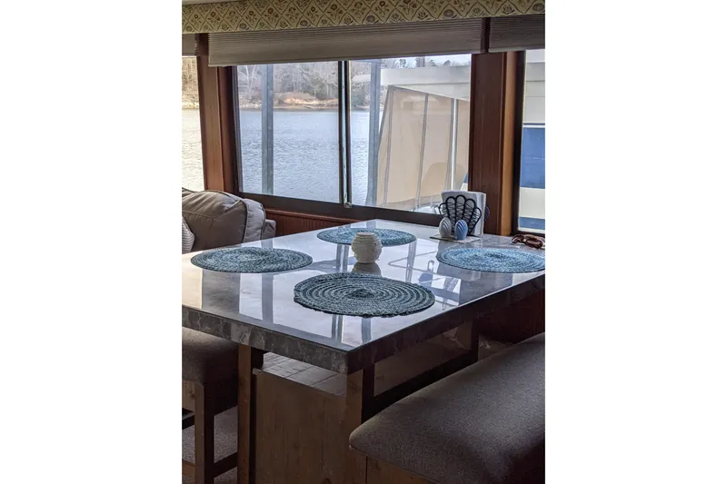 Sky To Sea Yacht Photos Pics Interior of 1984 Hatteras 53 Motor Yacht with dining area and scenic window view.