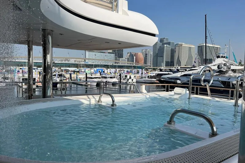 Sehamia Yacht Photos Pics Luxurious Gulf Craft Majesty 155 yacht with pool, docked in a marina, city skyline in background.