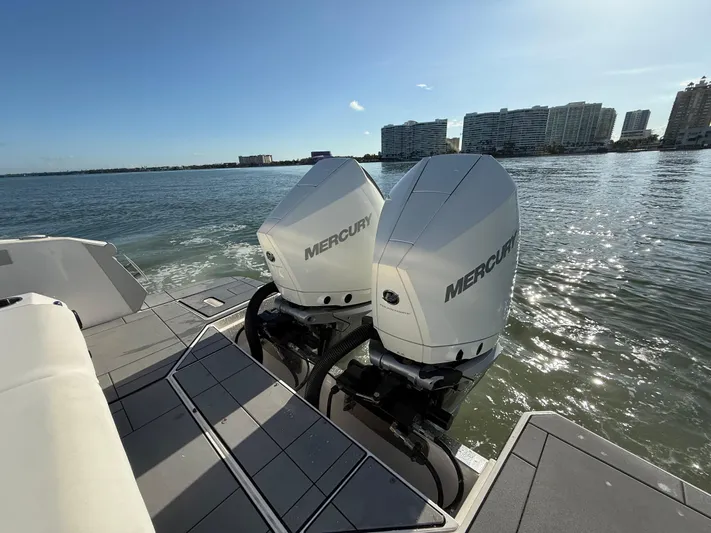  Yacht Photos Pics 2021 Aviara AV32 OB boat with twin Mercury outboard engines on a sunny waterfront.